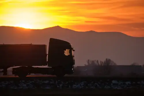Semi truck with cargo trailer driving on a highway